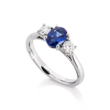 Image of an Oval Sapphire and Brilliant Cut Diamond Three Stone Ring in platinum