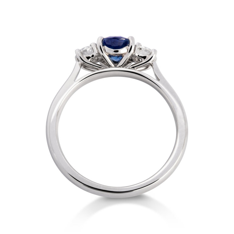 Image of an Oval Sapphire and Brilliant Cut Diamond Three Stone Ring in platinum