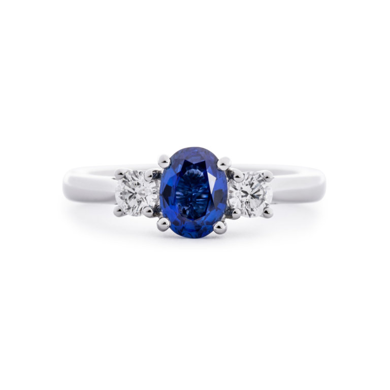 Image of an Oval Sapphire and Brilliant Cut Diamond Three Stone Ring in platinum