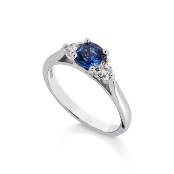 Image of a Cushion Sapphire and Brilliant Cut Diamond Three Stone Ring in white gold
