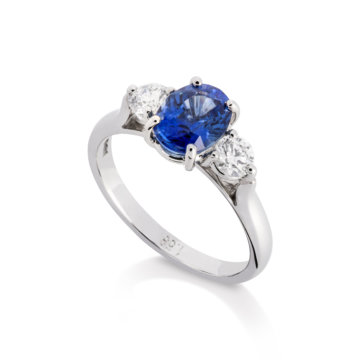 Image of an Oval Sapphire and Brilliant Cut Diamond Three Stone Ring in platinum