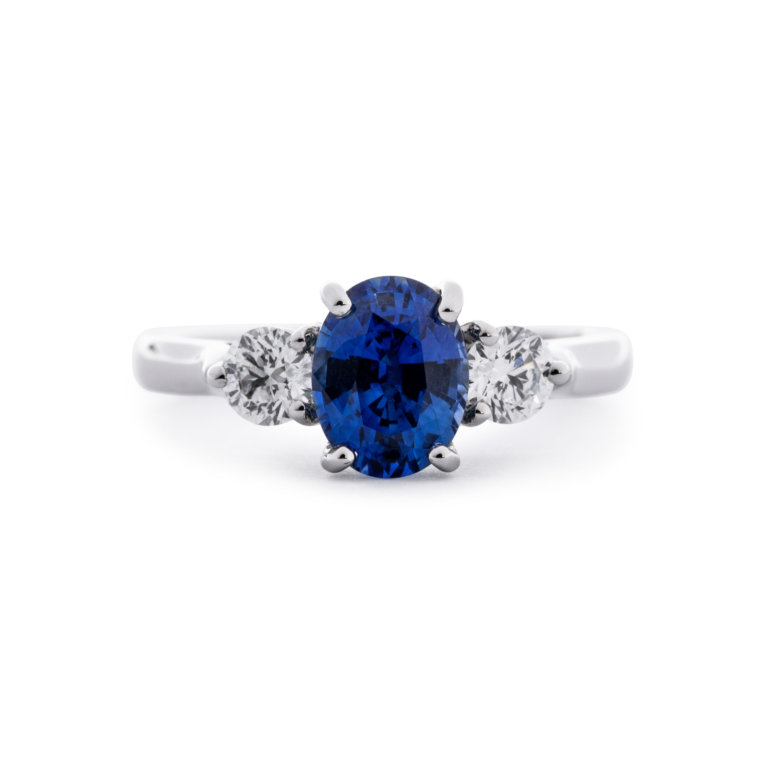 Image of an Oval Sapphire and Brilliant Cut Diamond Three Stone Ring in platinum