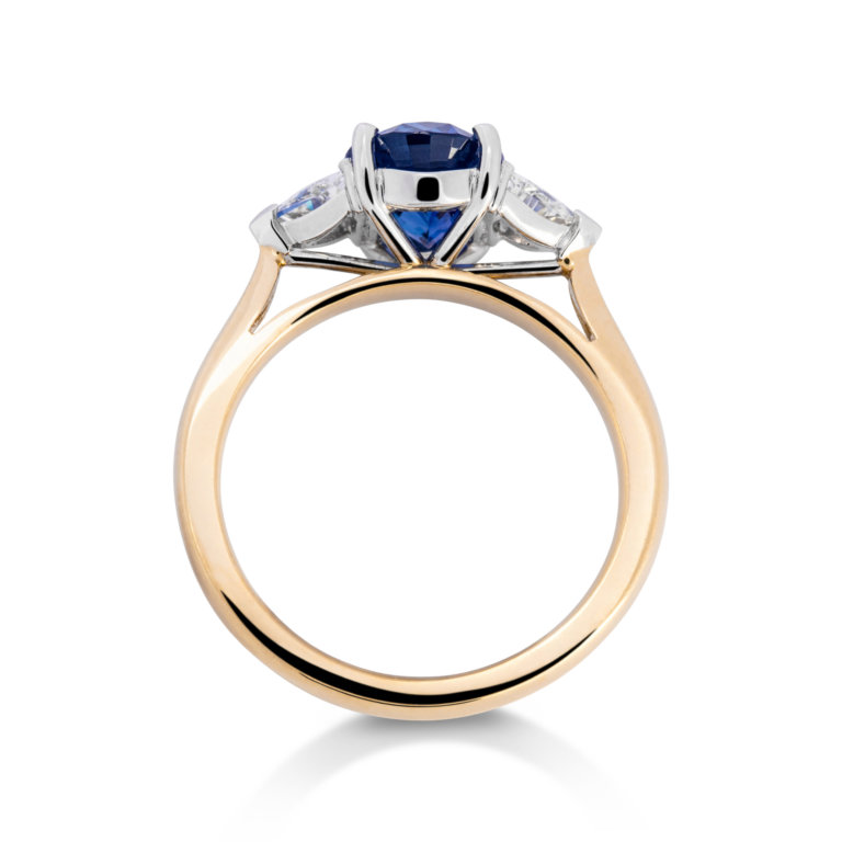 Image of an Oval Sapphire and Trilliant Cut Diamond Three Stone Ring in yellow gold and platinum