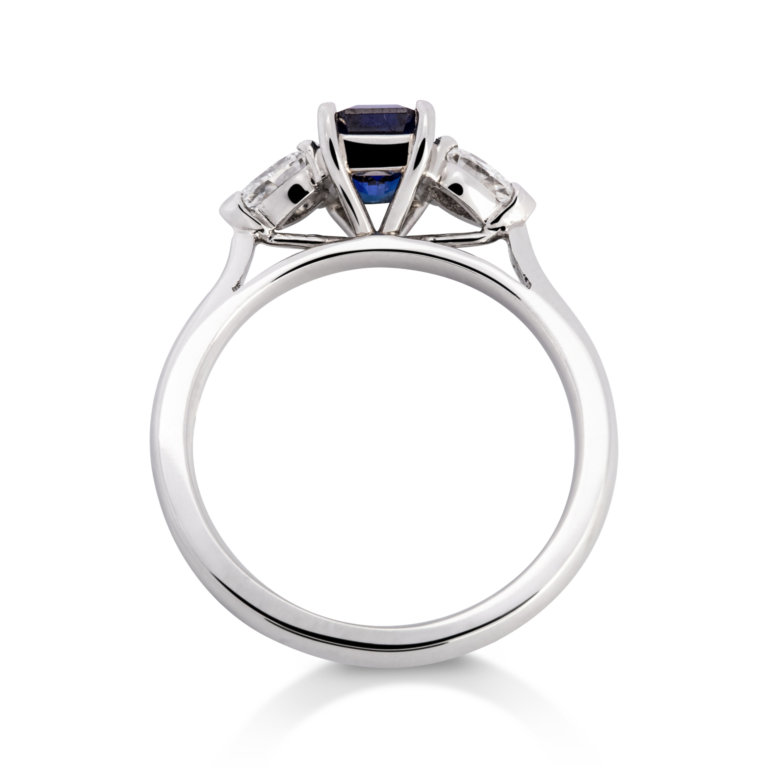 Image of an Emerald Cut Sapphire and Pear Cut Diamond Three Stone Ring in platinum