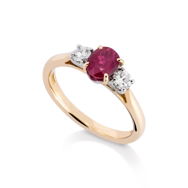 Image of an Oval Ruby and Brilliant Cut Diamond Three Stone Ring in yellow gold