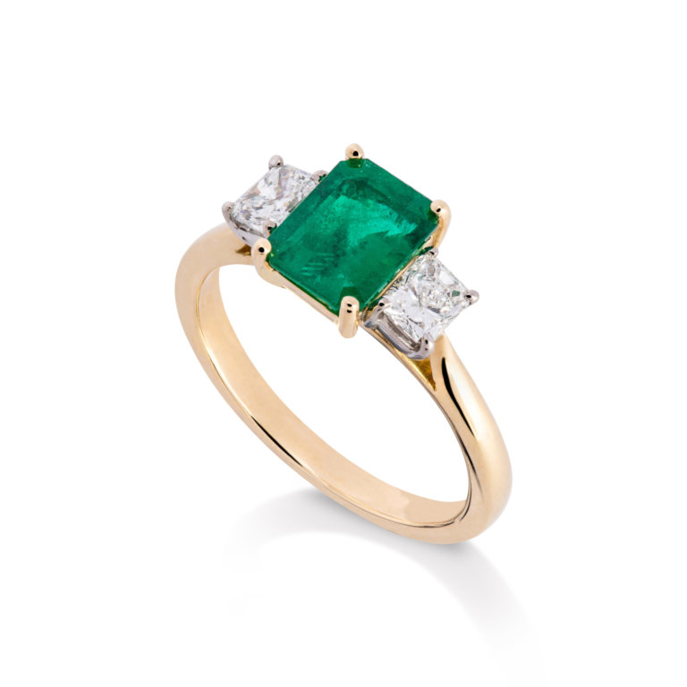 Image of an Emerald Cut Emerald and Radiant Cut Diamond Three Stone Ring set in yellow and white gold