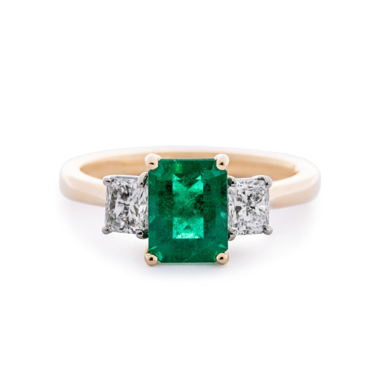 Image of an Emerald Cut Emerald and Radiant Cut Diamond Three Stone Ring set in yellow and white gold